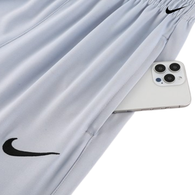 Calças desportivas cinzentas com bolso e telemóvel branco