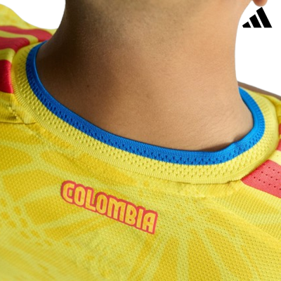 Gola azul e amarelo de camisola amarela com texto COLOMBIA e logótipo Adidas preto