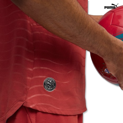 T-shirt vermelha com emblema circular e bola de futebol vermelha com detalhes azuis