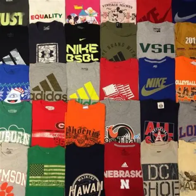 Várias t-shirts coloridas com estampas de marcas e textos, dispostas lado a lado