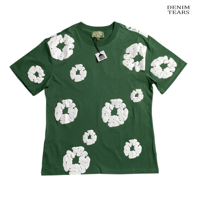 T-shirt verde com círculos brancos e etiqueta, texto Denim Tears