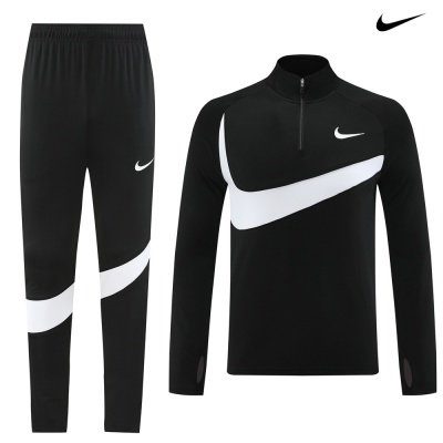 Conjunto desportivo Nike preto e branco com logótipo Swoosh e fecho.