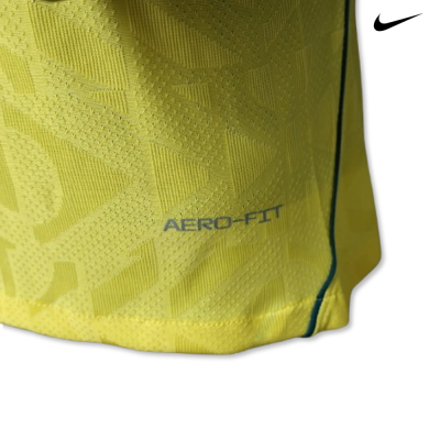 Pormenor de t-shirt desportiva amarela com padrão texturado e texto AERO-FIT