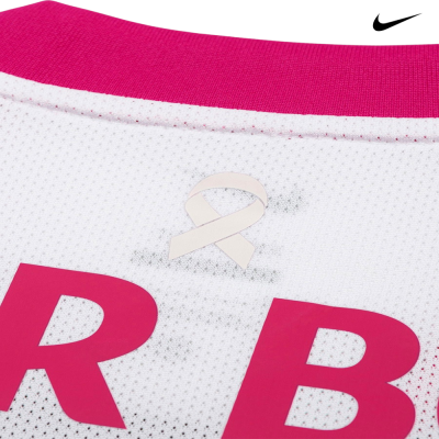 Detalhe de uma t-shirt branca com gola rosa e laço branco impresso.