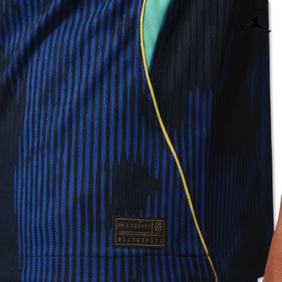 Tecido azul com riscas verticais pretas, linha amarela e etiqueta preta com texto dourado