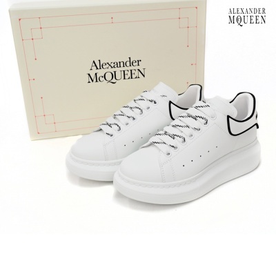 Ténis brancos Alexander McQueen com caixa de cartão creme.