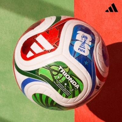 Bola de futebol Adidas colorida com textos FIFA e TRIONDA sobre fundo verde e vermelho.