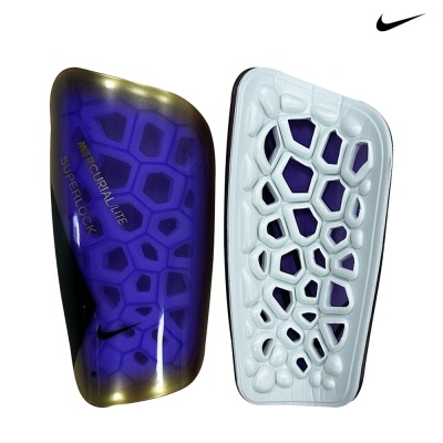 Caneleiras desportivas Nike com design hexagonal azul e dourado e verso branco com relevos