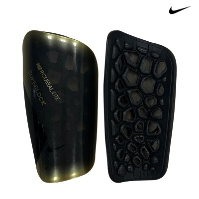 Conjunto de coxins protetores Nike preto e dourado para caneleiras com textura hexagonal