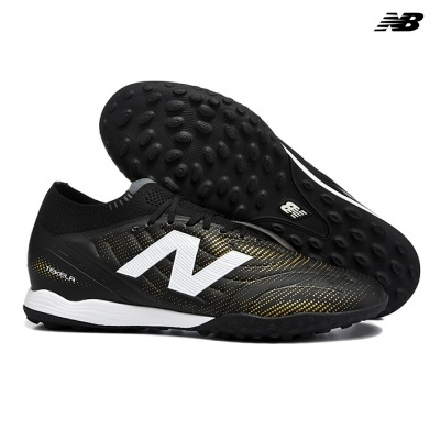 Chuteiras New Balance pretas com detalhes dourados e branco e sola preta texturizada