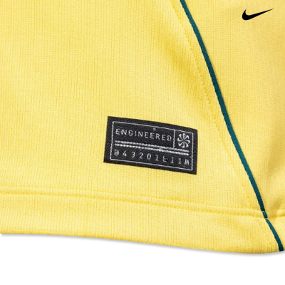 Etiqueta preta com texto em peça de vestuário amarela e logótipo Nike preto