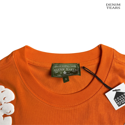 T-shirt laranja com etiquetas DENIM TEARS e DOVER STREET MARKET