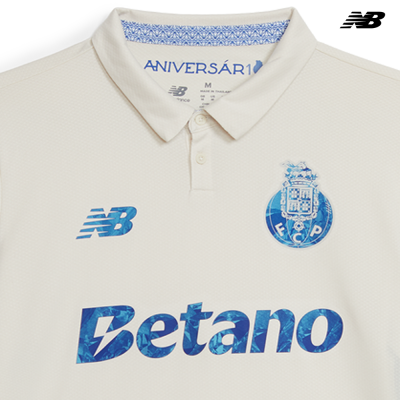 Polo branco com logos azuis do FC Porto, New Balance e Betano no peito.