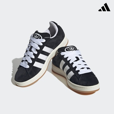 Sapatilhas Adidas pretas com riscas brancas e atacadores brancos.