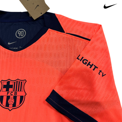 Camisola de futebol laranja com emblema FCB e texto LIGHT tv na manga