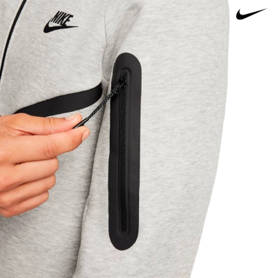 Casaco desportivo cinza claro com fecho no braço e logótipo Nike preto.