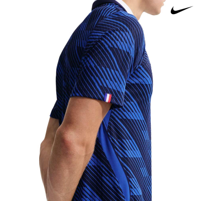 T-shirt desportiva azul com padrões geométricos e detalhe da bandeira francesa na manga