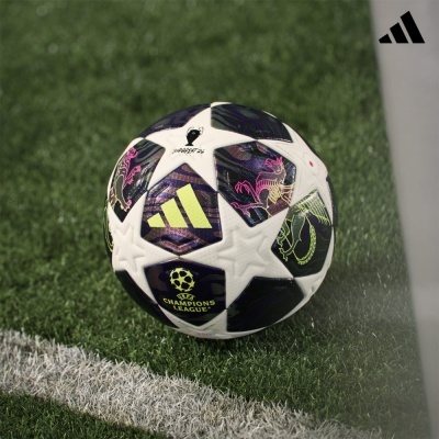 Bola de futebol Adidas branca e preta sobre relvado verde