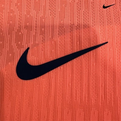 Pano coral com textura e logótipos Nike Swoosh pretos.
