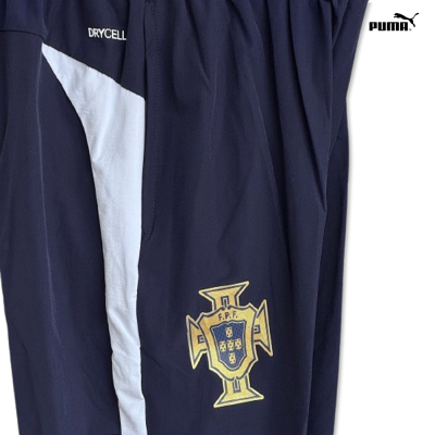 Calças desportivas azuis escuras com faixa branca lateral e logos DRYCELL e F.P.F.