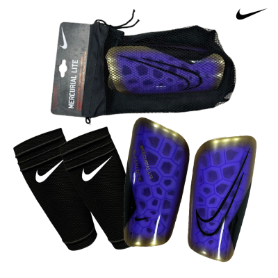Caneleiras Nike Mercurial Lite roxas e douradas com mangas pretas e saco de rede