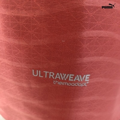 Tecido vermelho com padrão, texto ULTRAWEAVE thermoadapt e logótipo Puma