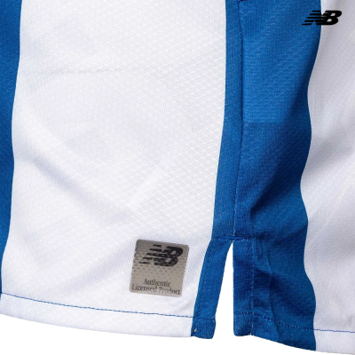 Peça de vestuário às riscas azuis e brancas com etiqueta Authentic Licensed Product e logotipo NB