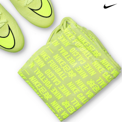 Chuteiras e saco Nike verde fluorescente com texto em várias línguas