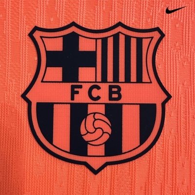 Emblema do FCB em tecido laranja com logotipo Nike acima