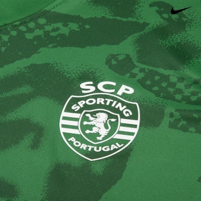 Tecido verde com padrão camuflado e emblema branco do Sporting Clube de Portugal com logo Nike
