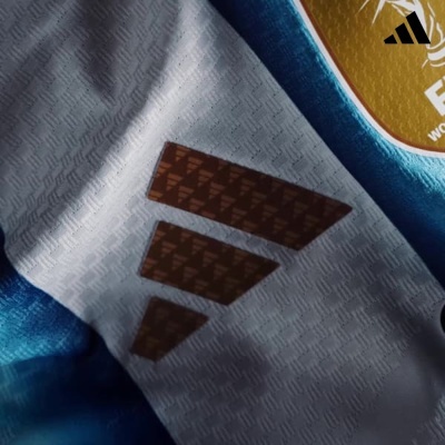 Camiseta branca e azul com logótipo Adidas castanho e símbolo FIFA amarelo e branco