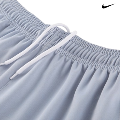 Calças azul claro com cintura elástica e cordão branco, logótipo Nike preto no canto superior direito