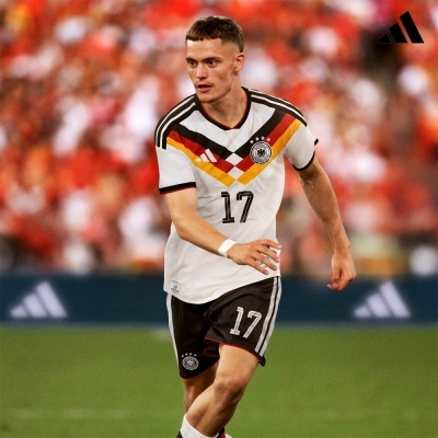 Jogador de futebol a usar camisola e calções da equipa nacional da Alemanha em campo.