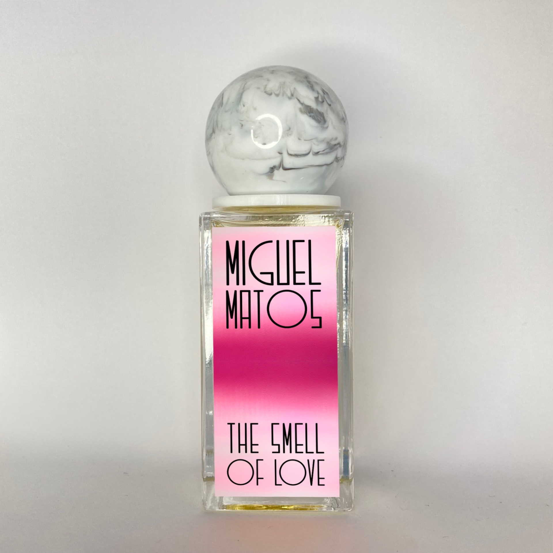 Frasco de perfume retangular com tampa esférica mármore e etiqueta rosa e fúcsia