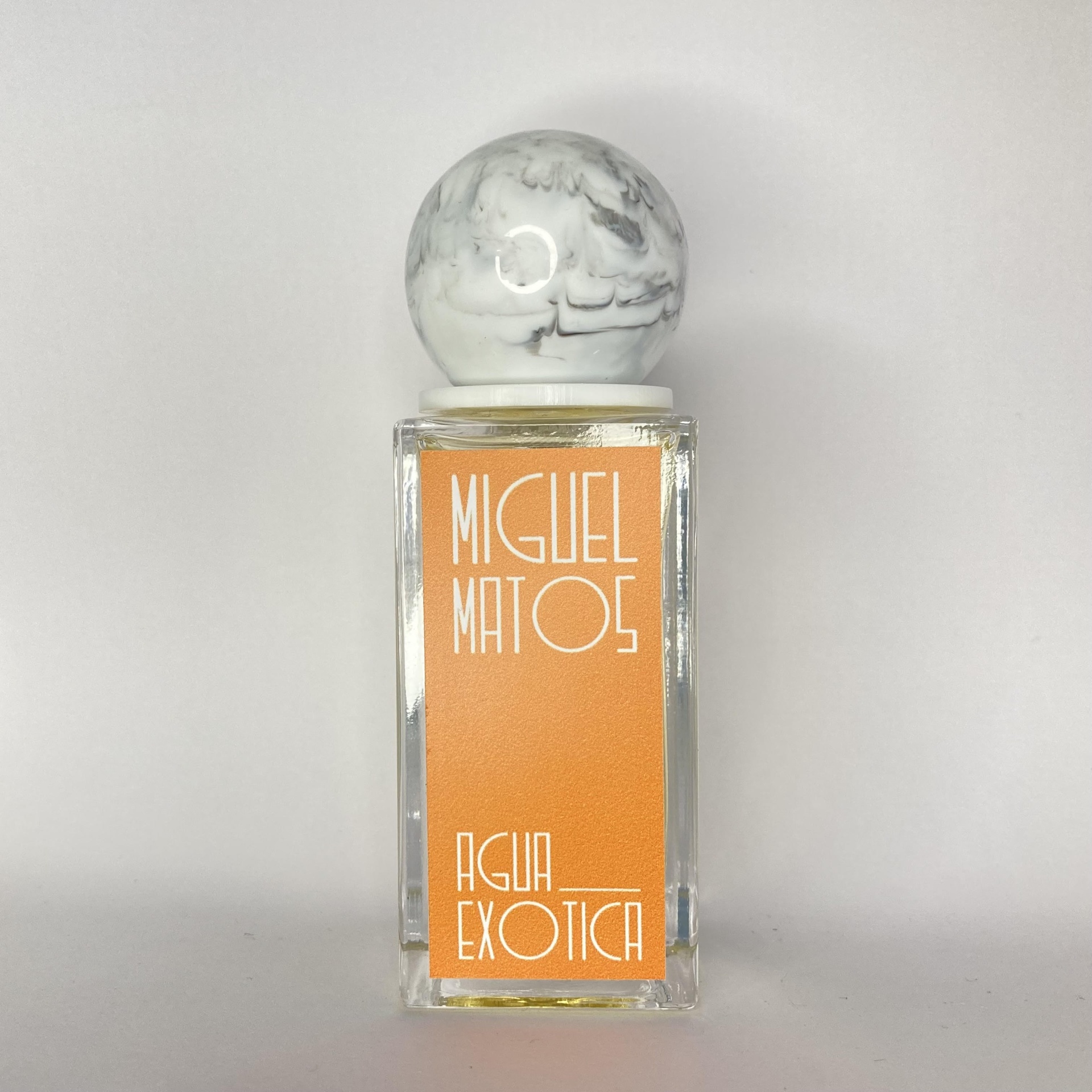 Frasco de perfume quadrado com tampa redonda marmoreada e rótulo laranja