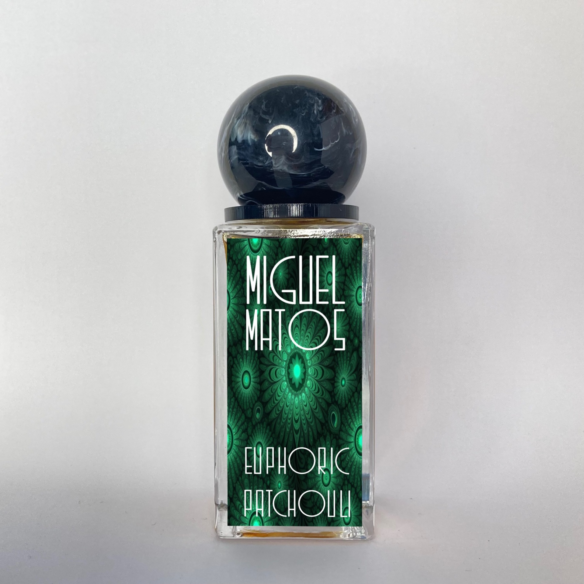 Frasco de perfume Miguel Matos Euphoric Patchouli com tampa preta e etiqueta verde