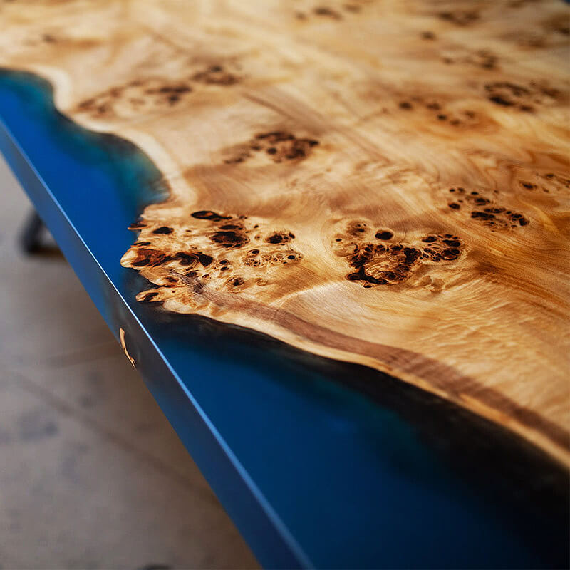 Mesa de madeira com bordas naturais e resina azul translúcida