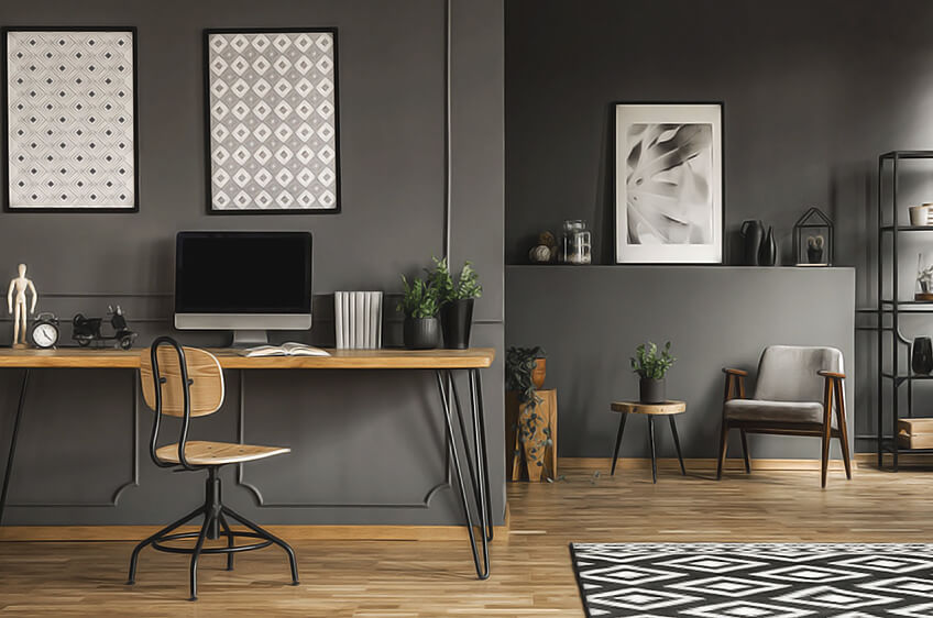 Espaço de escritório moderno com mobiliário em madeira, parede cinza e decoração minimalista.