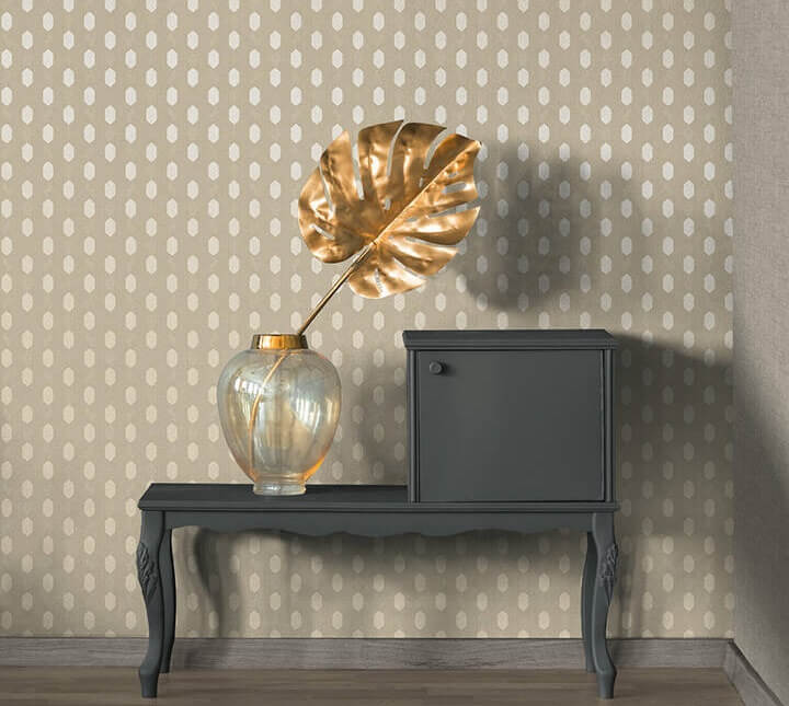 Papel de Parede Bege, Creme, Taupe Absolutely Chic | 36973-7 Banco cinza escuro com vaso vidro e folha dourada contra parede bege com padrão