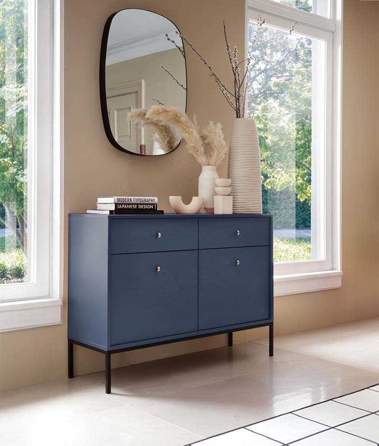 Aparador Azul Navi com Pernas em Preto Mono Móvel aparador azul escuro com decoração e espelho oval em parede bege