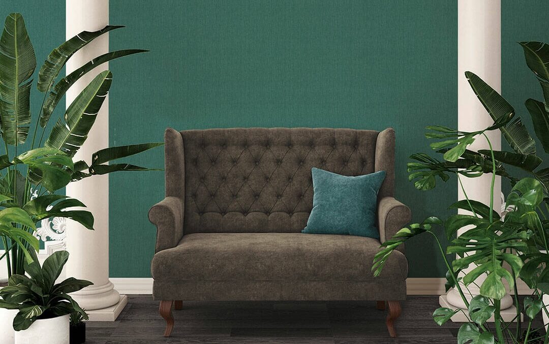 Papel de Parede Verde Ardósia Absolutely Chic | 36977-1 Sofá castanho capitonê com almofada azul e plantas verdes