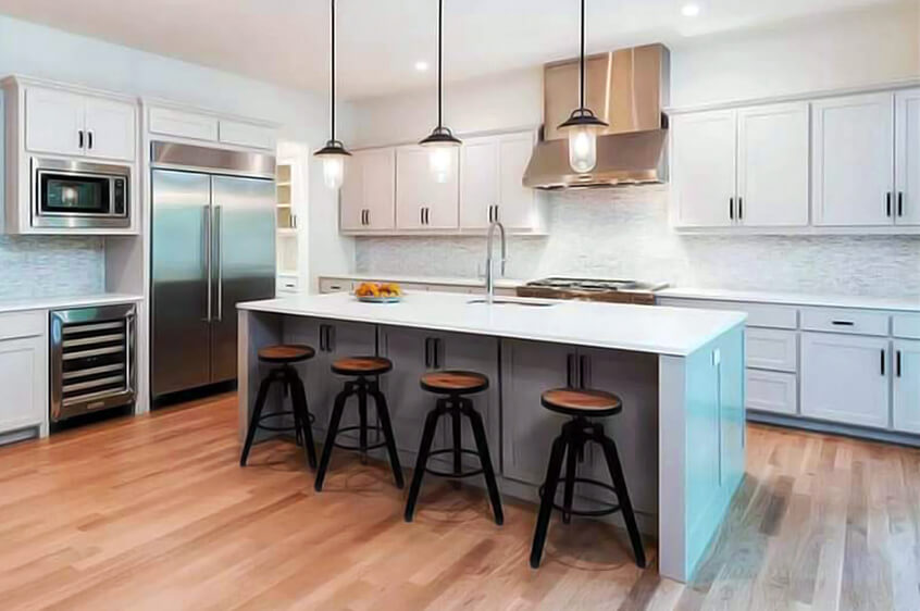 Cozinha moderna com bancada central branca e quatro bancos de madeira