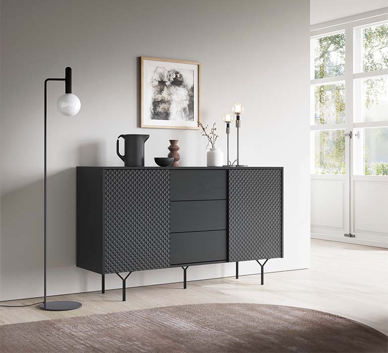 Aparador Minimalista Cinzento e Preto Raven Aparador preto com textura geométrica e luminária de pé preta junto à parede cinza