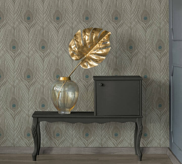 Papel de Parede Cinzento Absolutely Chic | 36974-9 Mesa de apoio preta com jarra transparente e folha dourada decorativa contra papel de parede com padrão de penas