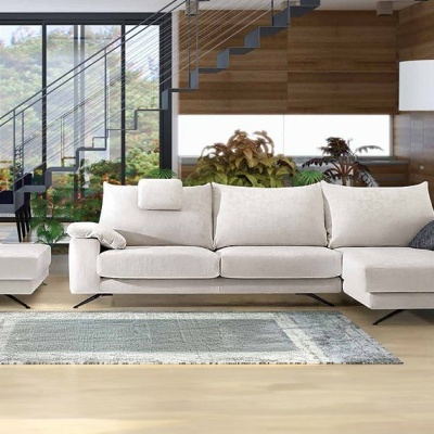 Sofá seccional creme com mesa de centro branca em sala moderna com janelas amplas