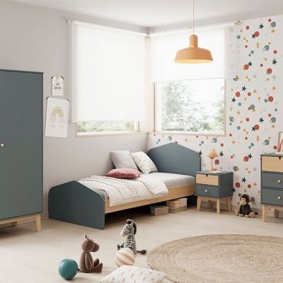 Quarto infantil com móveis cinza, papel de parede colorido, tapete bege, candeeiro laranja, brinquedos e janelas com estores.