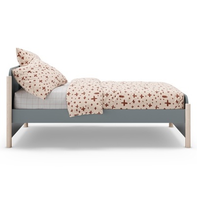 Cama infantil com roupa de cama branca e cruzes castanhas.