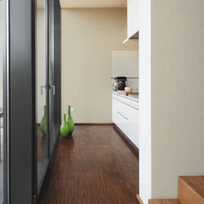 Interior de casa com escadas de madeira, cozinha branca e porta de vidro para área exterior com mesa e cadeiras.