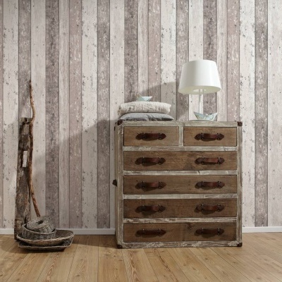 Cômoda rústica com puxadores de couro numa sala com papel de parede às riscas e candeeiro