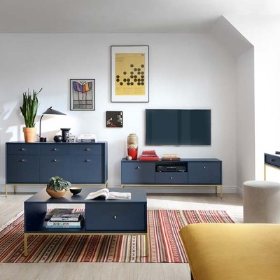 Sala com mobília azul escura, sofá amarelo, quadros na parede e tapete às riscas